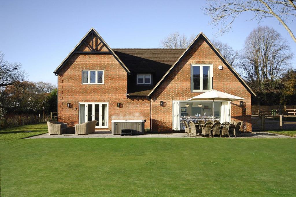 een groot bakstenen huis met een tafel en stoelen bij Hayward House, Hot Tub, Large Garden in Henley on Thames