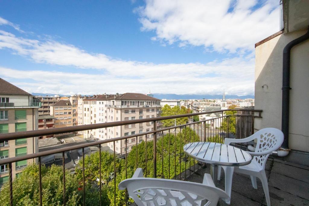 einen Balkon mit einem Tisch und Stühlen sowie Aussicht in der Unterkunft Primadom Aparthotel in Genf