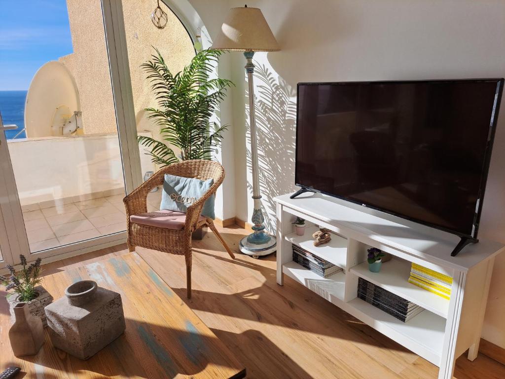 a living room with a flat screen tv on a white entertainment center at la ventana al mar in Jávea