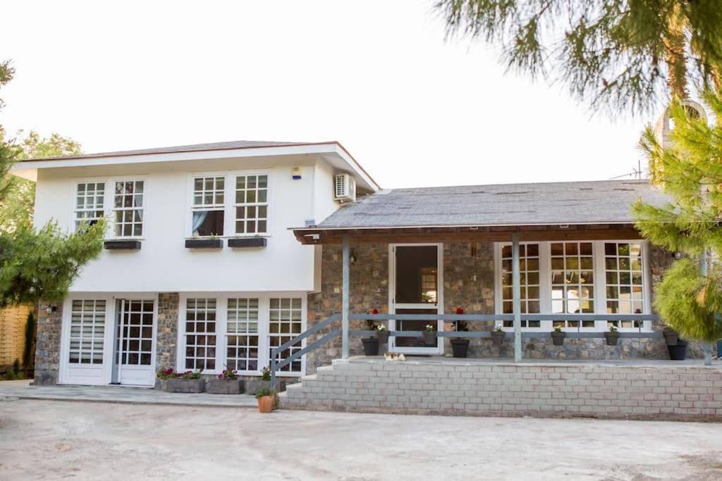 a white house with windows and a porch at Greece Seaside villa 200sq m 20m from sea in Káto Alepokhórion