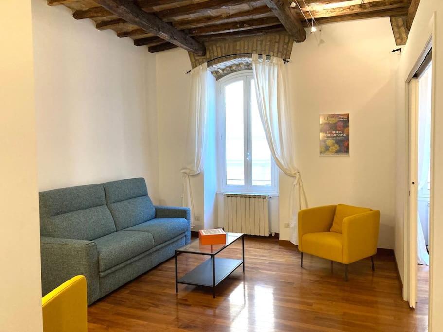 un salon avec un canapé bleu et un fauteuil jaune dans l'établissement Vatican Vacation Home Interno 2, à Rome