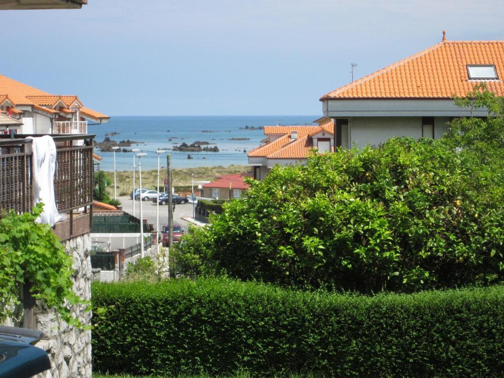 a view of a city with houses and the ocean at Habitaciones López Azcona in Noja