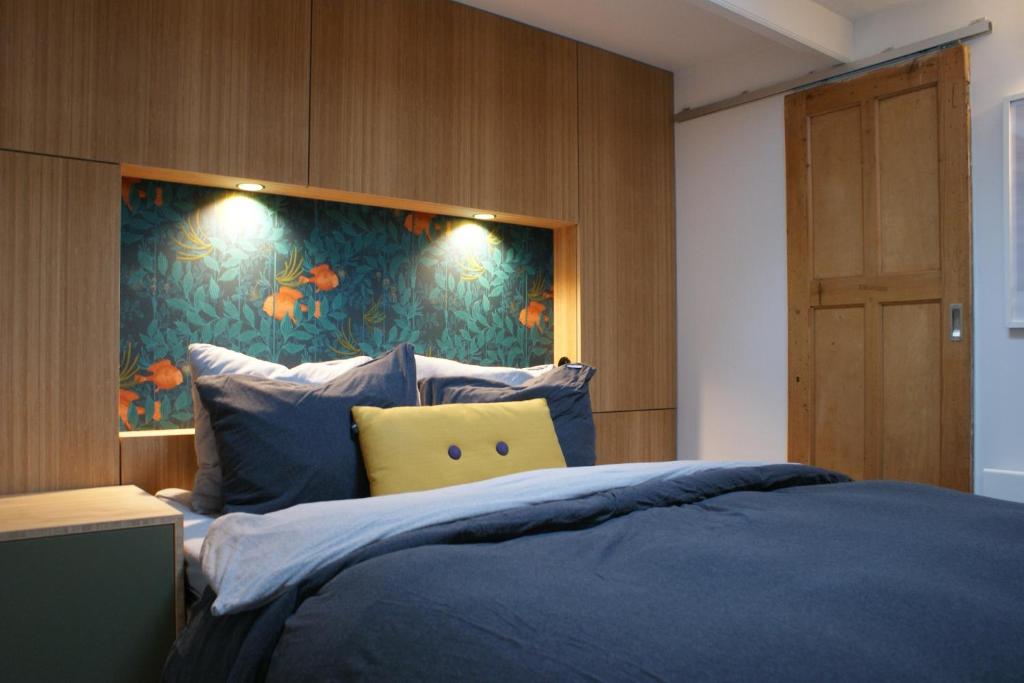 ein Schlafzimmer mit einem blauen Bett und einem gelben Kissen in der Unterkunft Sommarhus in Zandvoort