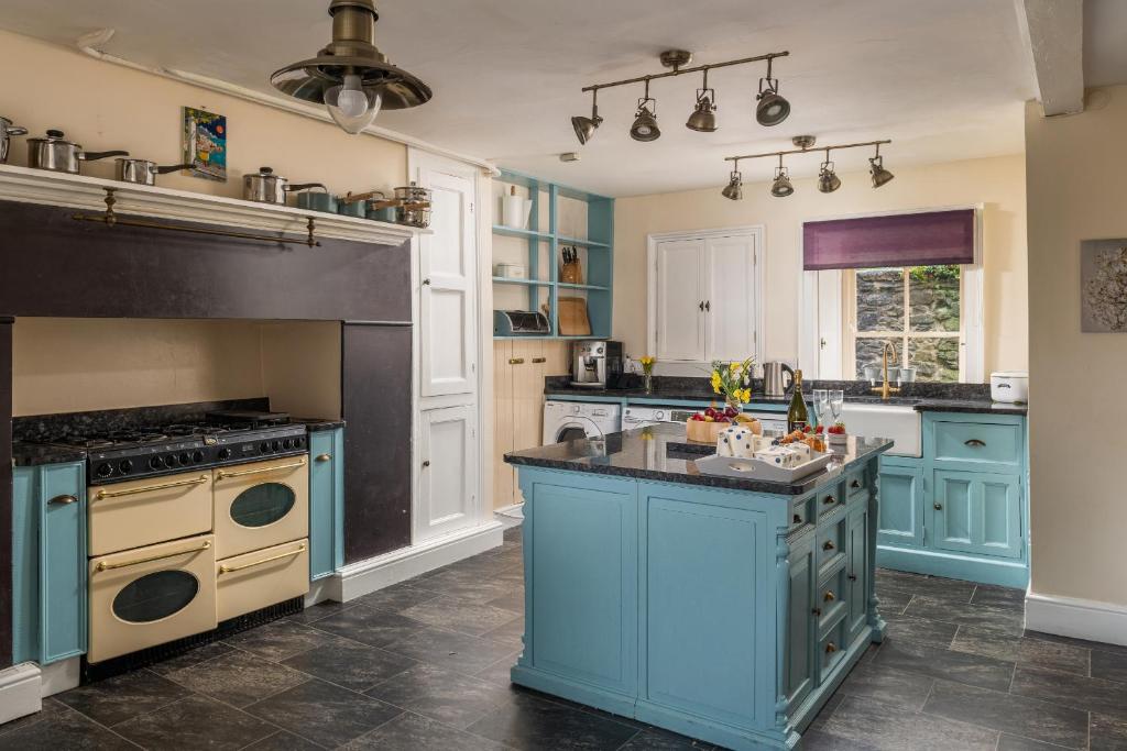 a large kitchen with blue cabinets and a blue island at Finest Retreats - Bryn Seion in Llanrwst
