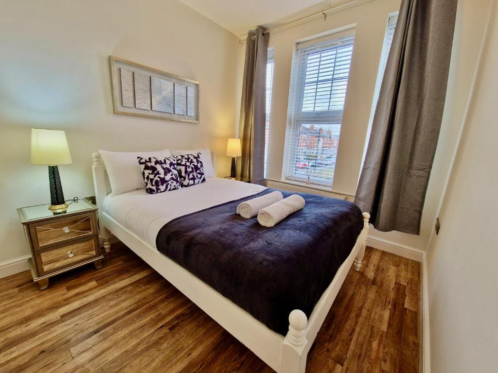 1 dormitorio con 1 cama con 2 almohadas y ventana en Spacious Luxury Serviced Apartment next to City Centre with Free Parking - Contractors & Relocators, en Coventry