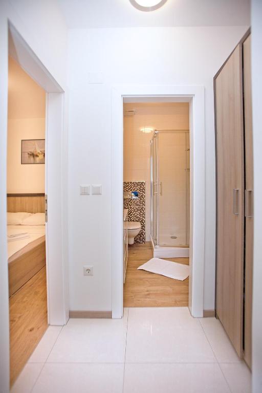 biała łazienka z toaletą i umywalką w obiekcie Apartments Maslina III w mieście Nijvice