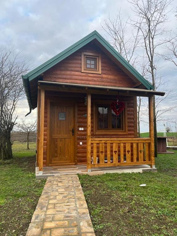 a small log cabin with a porch and a door at Salaš Gnijezdo in Bačka Palanka