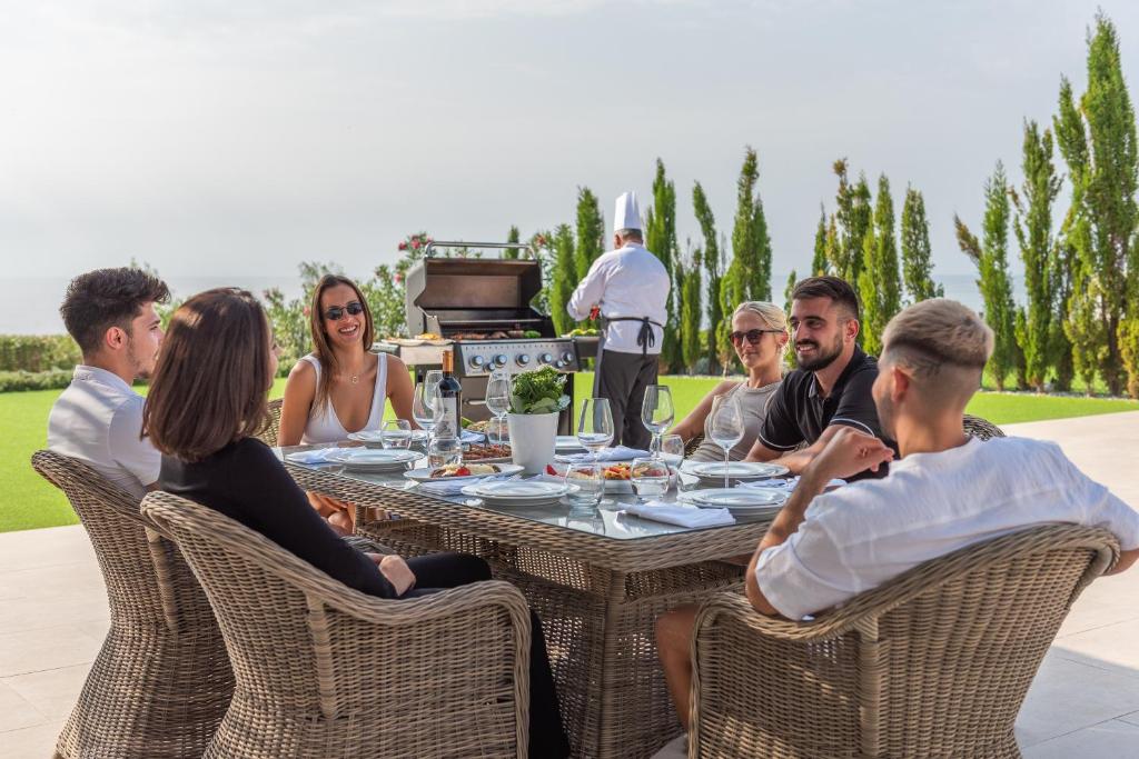 a group of people sitting around a table at Cap St Georges Villas in Peyia