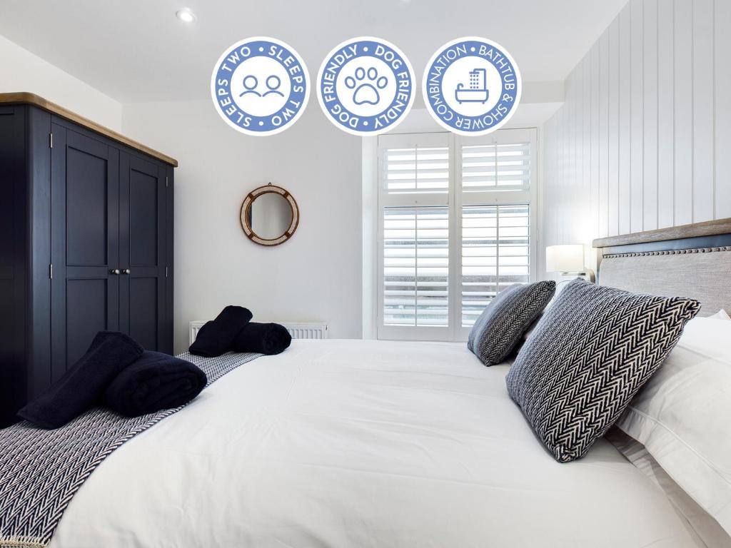 um quarto com uma cama grande com placas azuis e brancas na parede em Driftwood Boutique Guest House em Rhosneigr