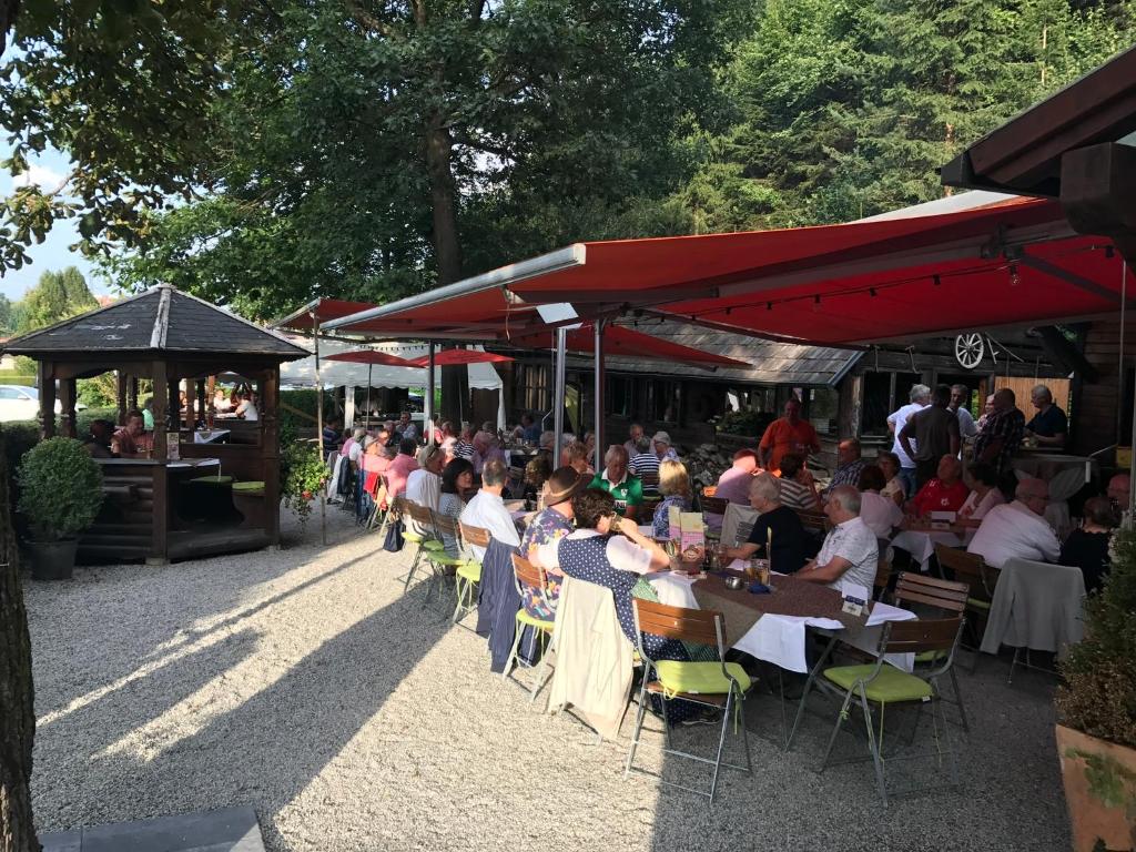 um grupo de pessoas sentadas em mesas em um restaurante em Waldrestaurant VIDA em Kapfenberg