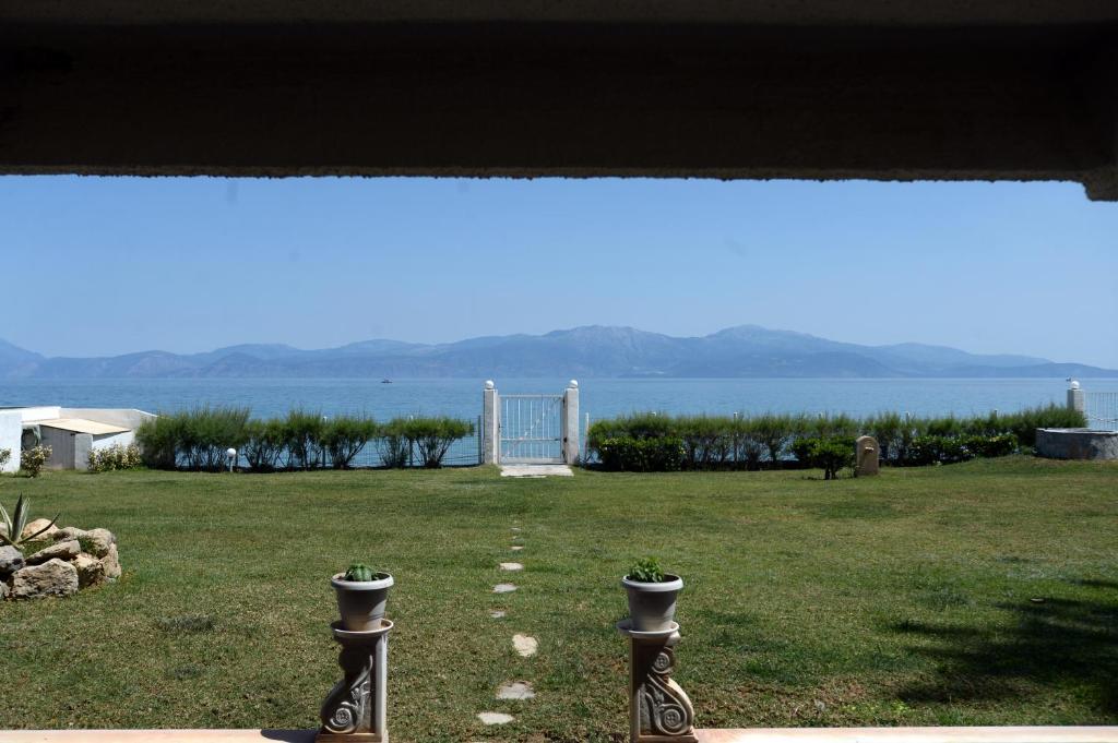 a view of a yard with a view of the water at Antorina Grande beachfront house in Kamárion