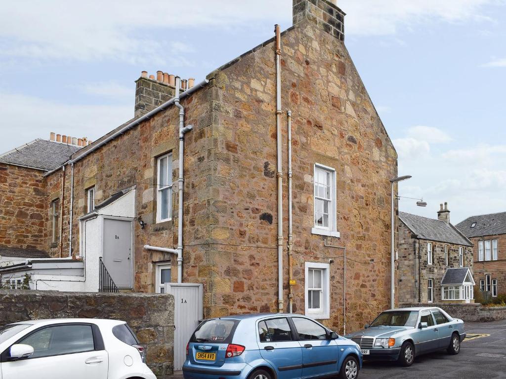 two cars parked in front of a brick building at Arc House in Cellardyke