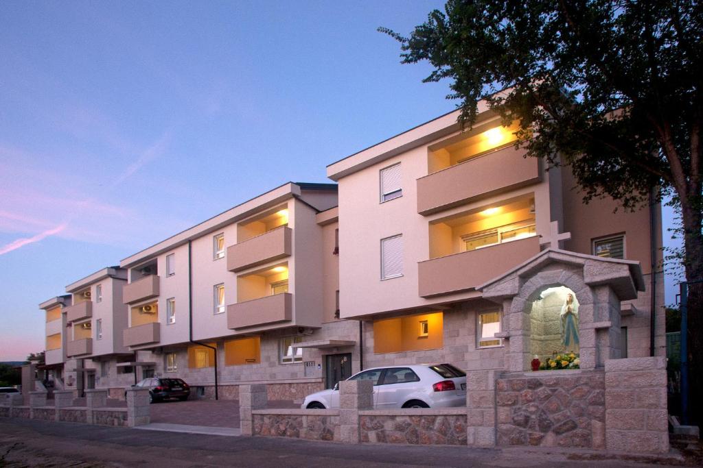 budynek z zaparkowanym przed nim samochodem w obiekcie Apartments Maslina III w mieście Nijvice