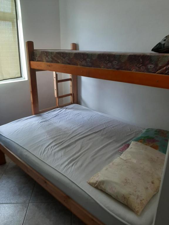 a bed in a room with a bunk bed at Sobrado Em Matinhos Pr in Matinhos