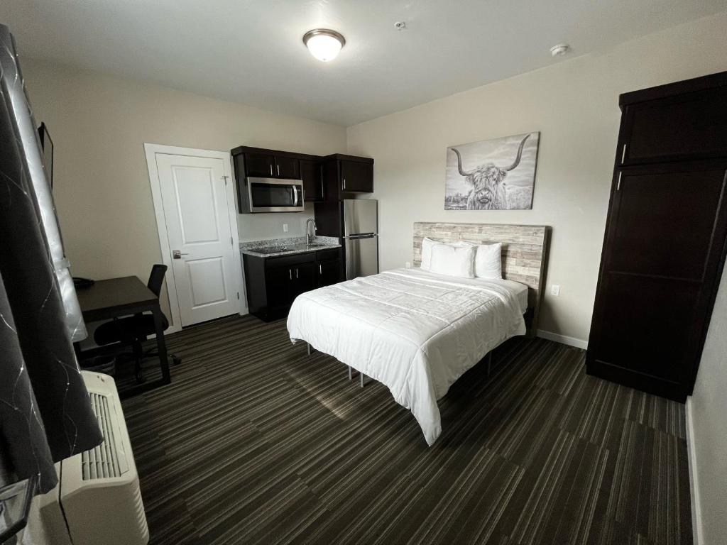 a hotel room with a bed and a kitchen at Longhorn Flats in Loving