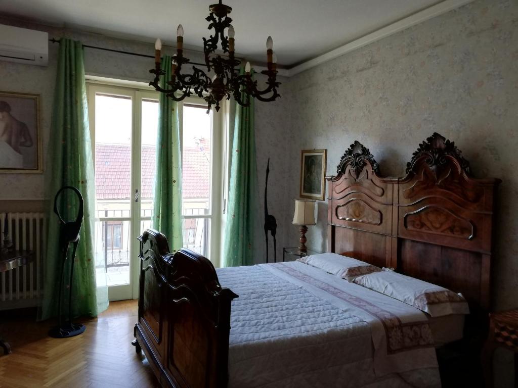 a bedroom with a large wooden bed with green curtains at Yellow House in Turin