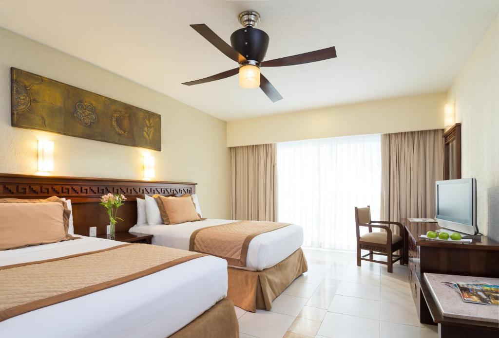 Habitación de hotel con 2 camas y ventilador de techo. en BlueBay Grand Esmeralda-All Inclusive, en Playa del Carmen