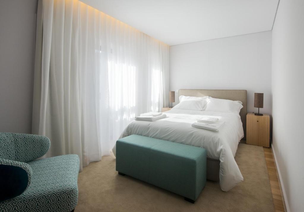 a bedroom with a white bed and a blue stool at Domum in Porto