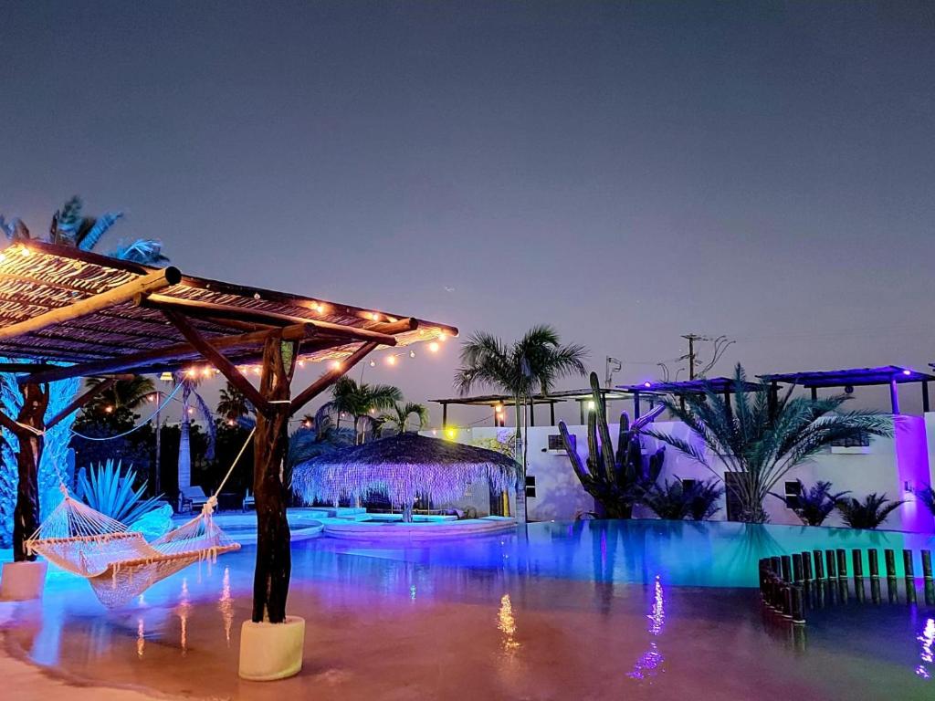 a resort with blue lights and palm trees at Ventana Blue Hotel in El Sargento