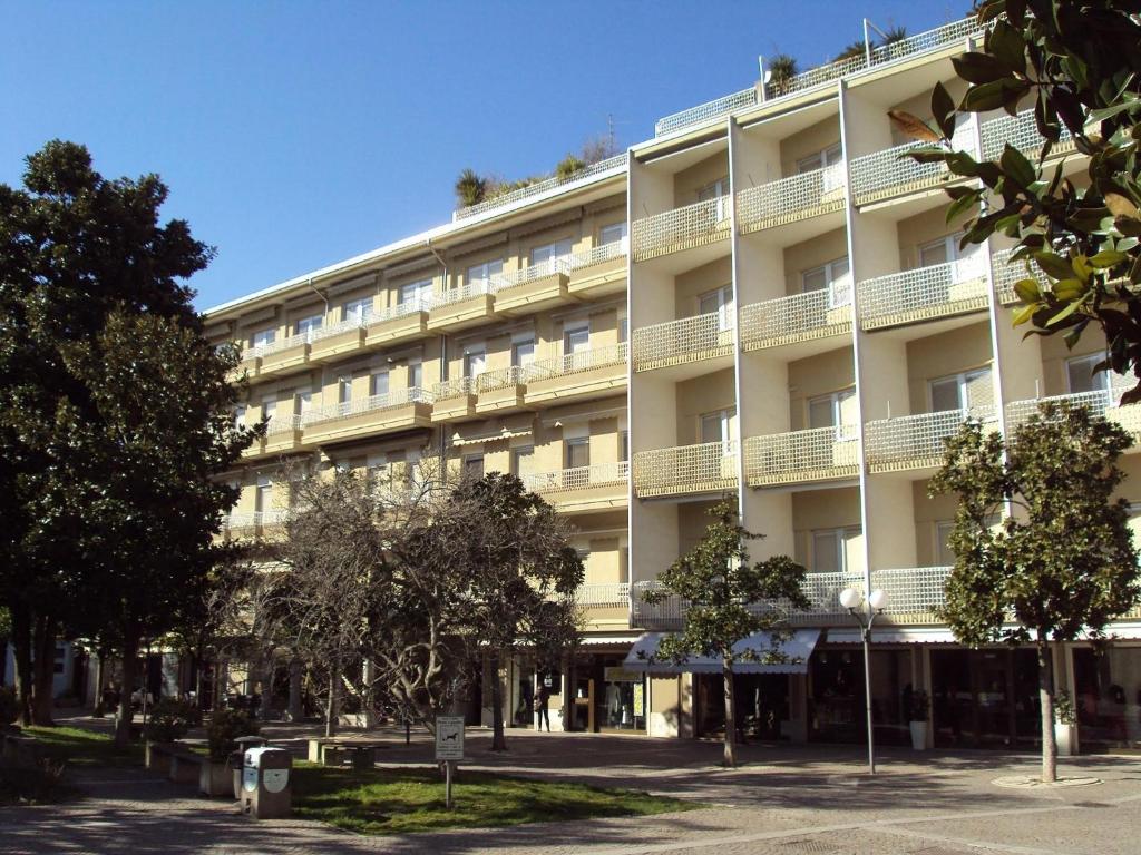 um grande edifício branco com árvores em frente em Parco Salute em Grado