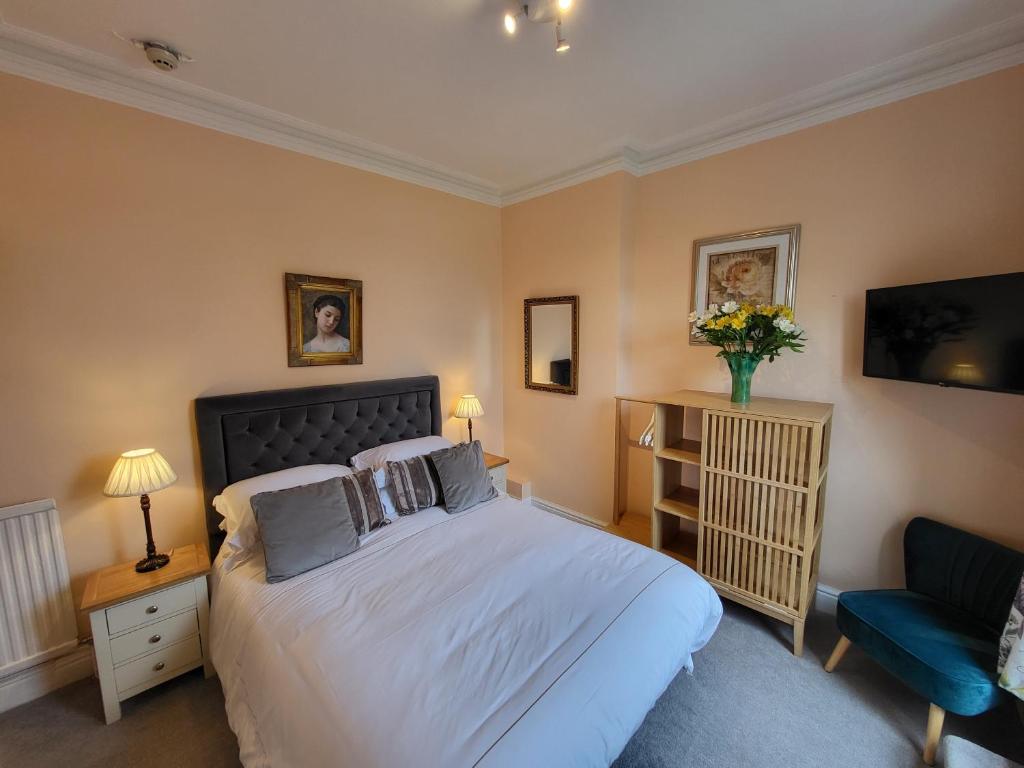 een slaapkamer met een groot bed en een blauwe stoel bij Georges Place in York