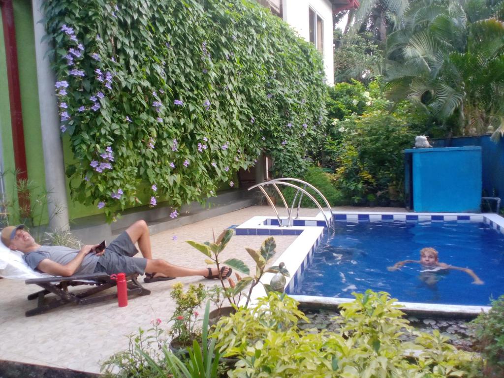 - deux personnes assises sur des chaises à côté d'une piscine dans l'établissement Abha Villa with Private pool, à Galle