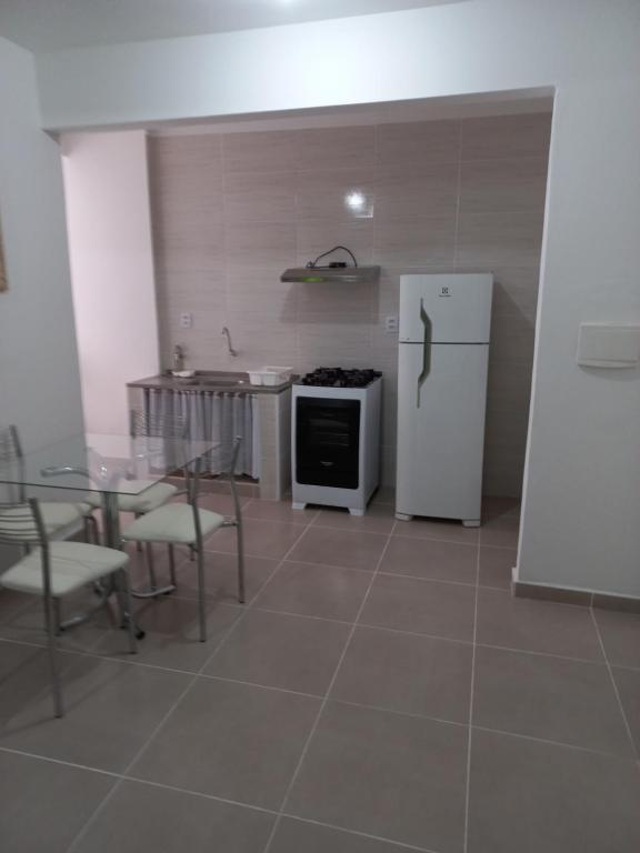 cocina con nevera, mesa y sillas en Apartamento living, en São Vicente