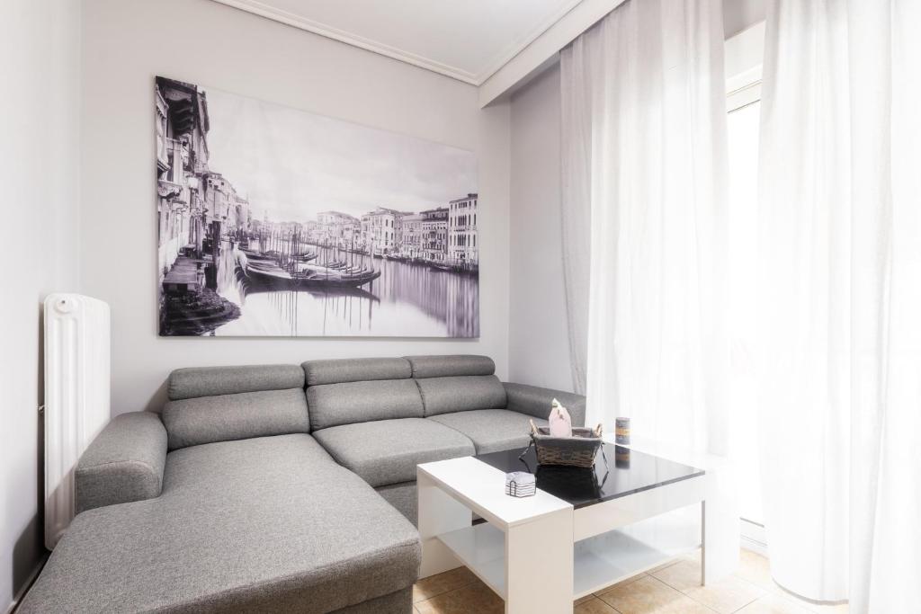 un salon avec un canapé et une table dans l'établissement Renovated penthouse in the center of Larissa, à Larissa