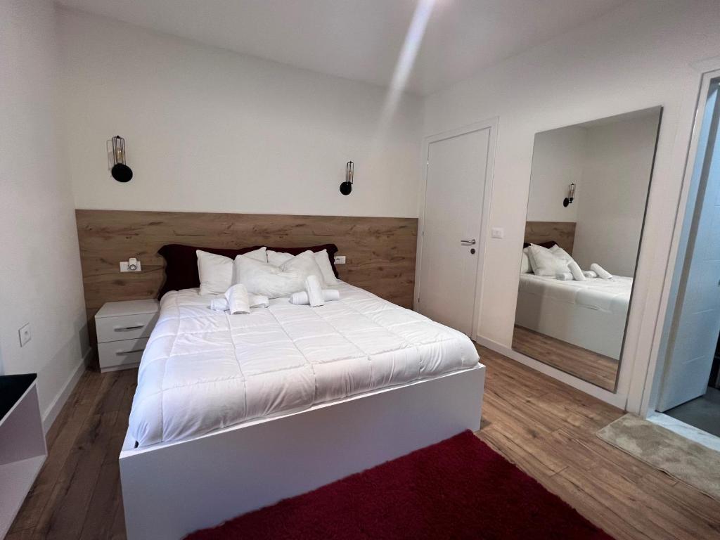 um quarto com uma cama branca e um espelho em Grand Park & Bllok Area Rooms em Tirana