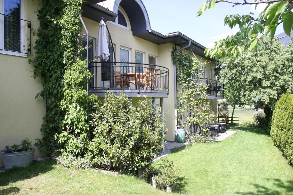 ein Gebäude mit einem Tisch und Stühlen auf einem Balkon in der Unterkunft Zillertal Appartements in Fügen