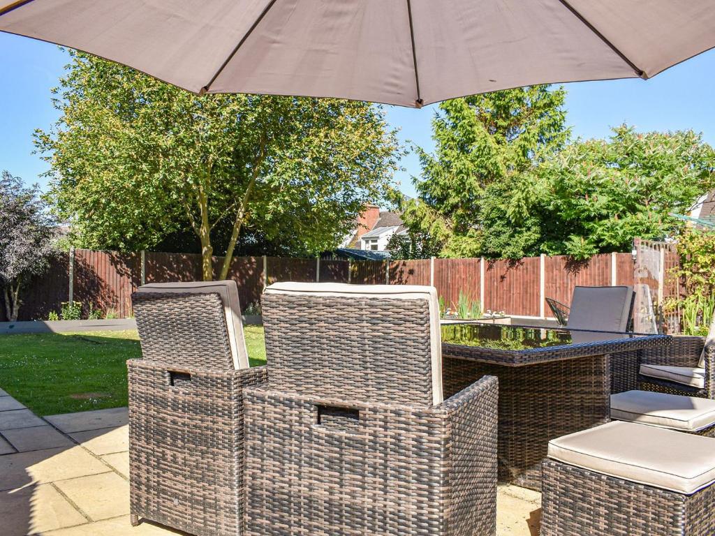 a patio with two chairs and an umbrella at Jarvea in Beckford