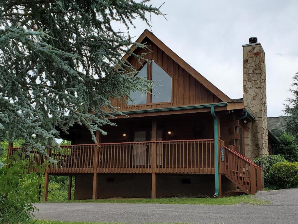 セバービルにあるStory Brook: Beautiful true log cabin! Close to Dollywood, State Park, and more!の大きな木造の家(大きなバルコニー付)