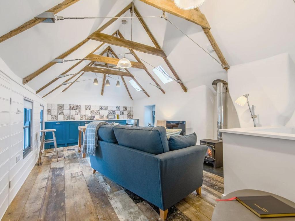 a living room with a blue couch and wooden floors at 9 Chapel Street in Mousehole