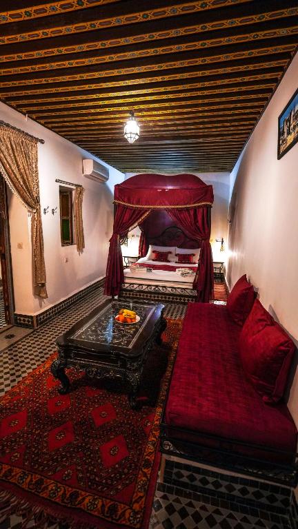 una grande camera con un letto e un divano di Riad Green House a Fes