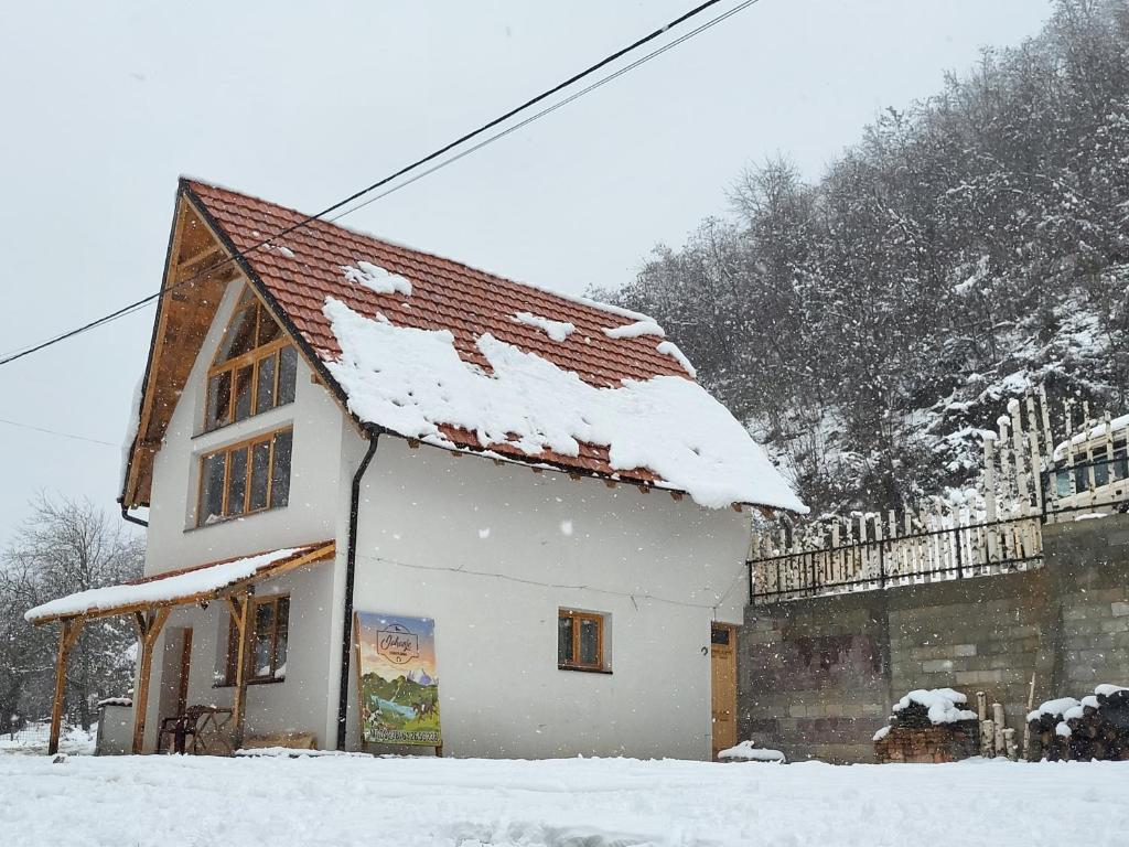 a white building with snow on the roof at Antić apartmani Stara planina in Crni Vrh