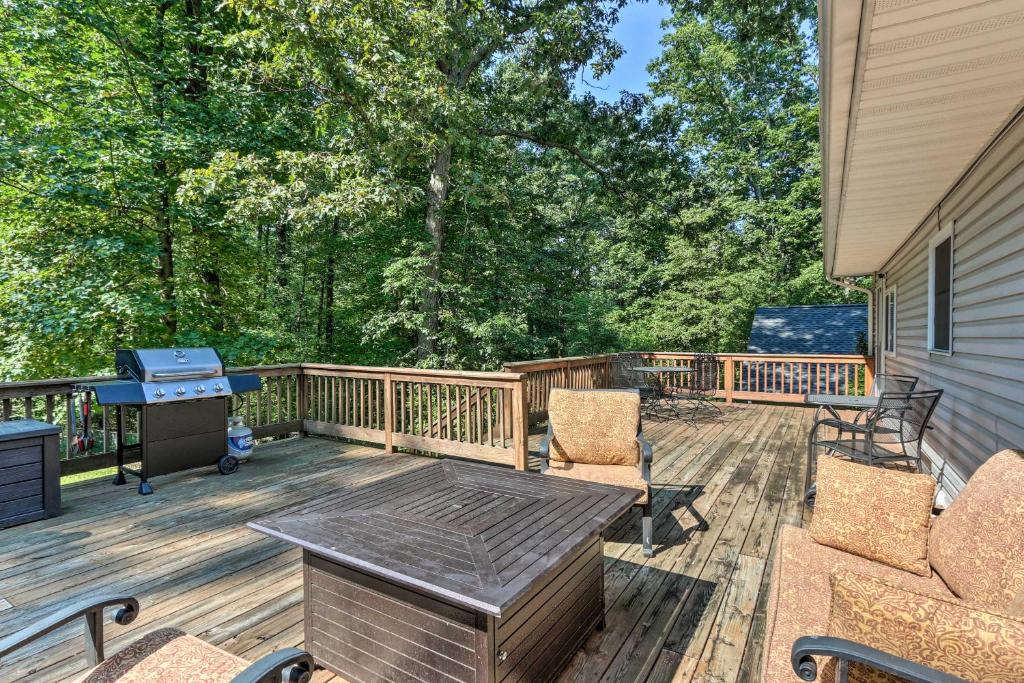 a deck with a table and chairs and a grill at Harpers Ferry Cabin - Walk to Private Lake! in Harpers Ferry