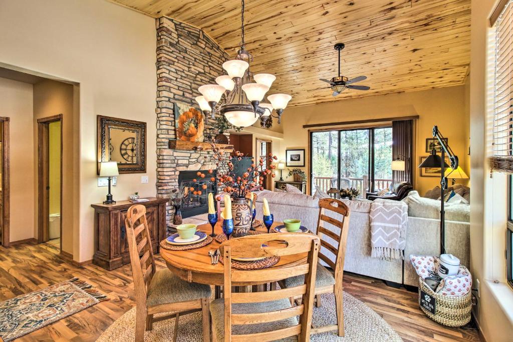 a dining room and living room with a table and chairs at Fireside Comfort and Family Fun Wooded Show Low Gem in Show Low
