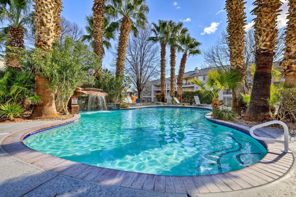 a swimming pool with palm trees in a yard at Beautiful St George Condo about 5 Mi to Downtown! in St. George