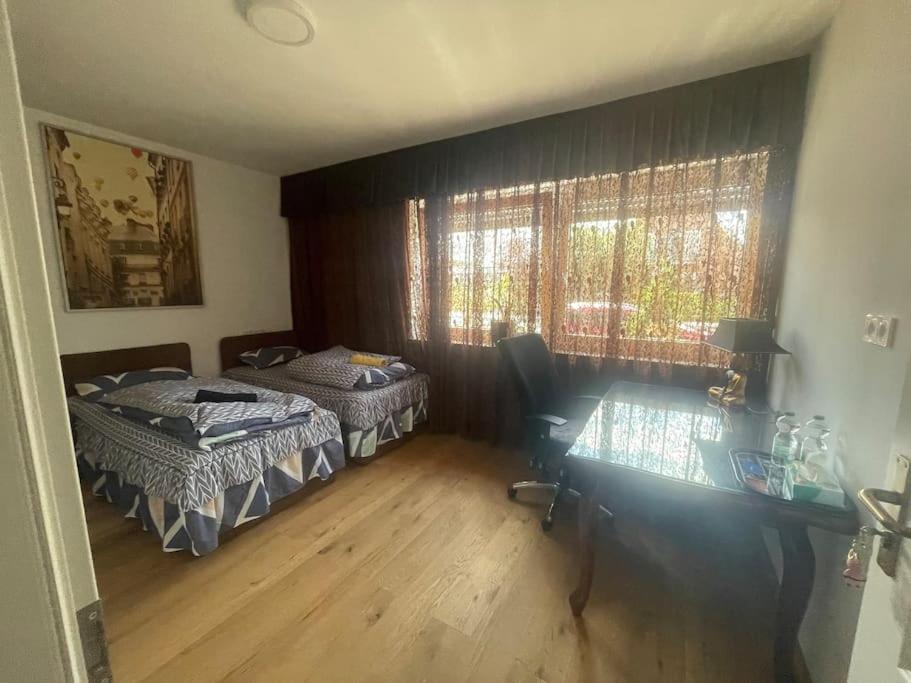 een slaapkamer met 2 bedden, een bureau en een raam bij 2Schlafenzimmer waschen möglich in Mönchengladbach