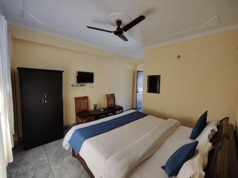 een slaapkamer met een groot bed en een plafondventilator bij RNB Beach Stay in Anjuna