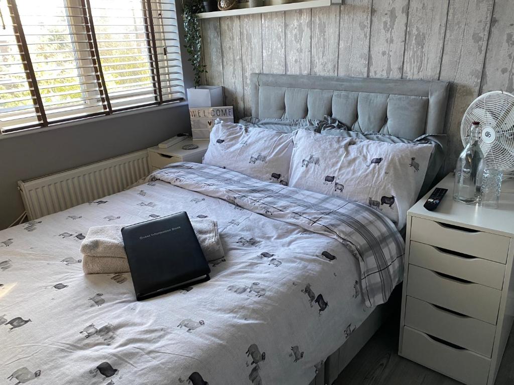 a bedroom with a bed with a laptop on it at Willow Guest House in Norwich