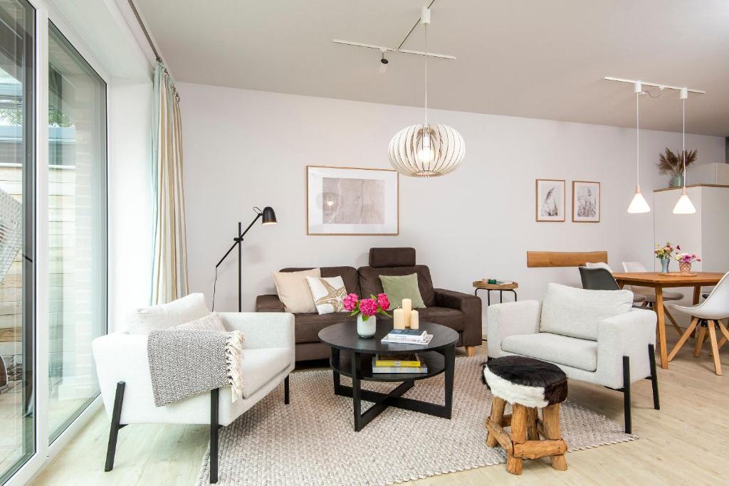 uma sala de estar com um sofá, cadeiras e uma mesa em Alte Waescherei _9463_ em List