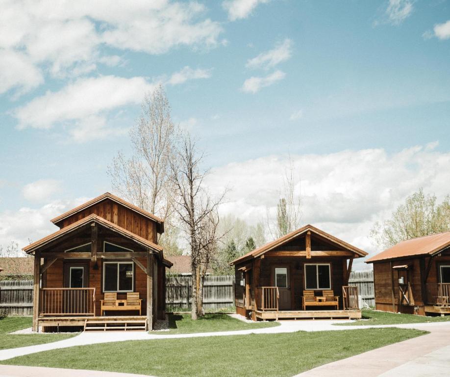 a group of cottages on a grass field at Teton Valley Resort in Victor