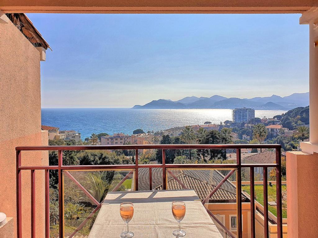 einen Balkon mit Tisch und 2 Weingläsern in der Unterkunft Cocon cannois in Cannes