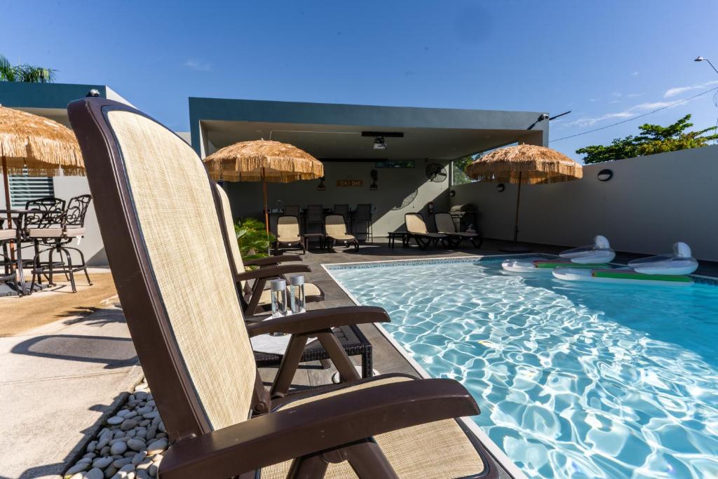 a pool with chairs and umbrellas on a patio at Aquaville Dorado Moderna A Studio 7 in Dorado