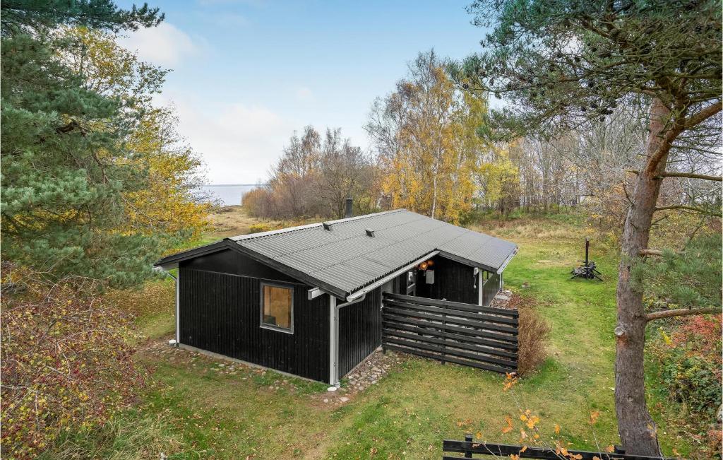 una cabaña negra en medio de un campo en 3 Bedroom Cozy Home In Nykbing Sj, en Bøsserup