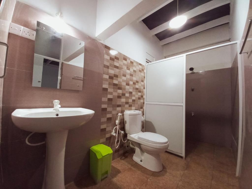 een badkamer met een wastafel, een toilet en een spiegel bij Glance Beach Ahangama in Ahangama