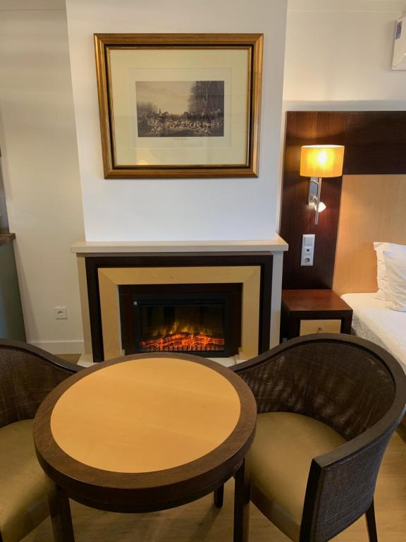 a room with a fireplace and a table and chairs at Discovery Apartment Carnaxide in Carnaxide