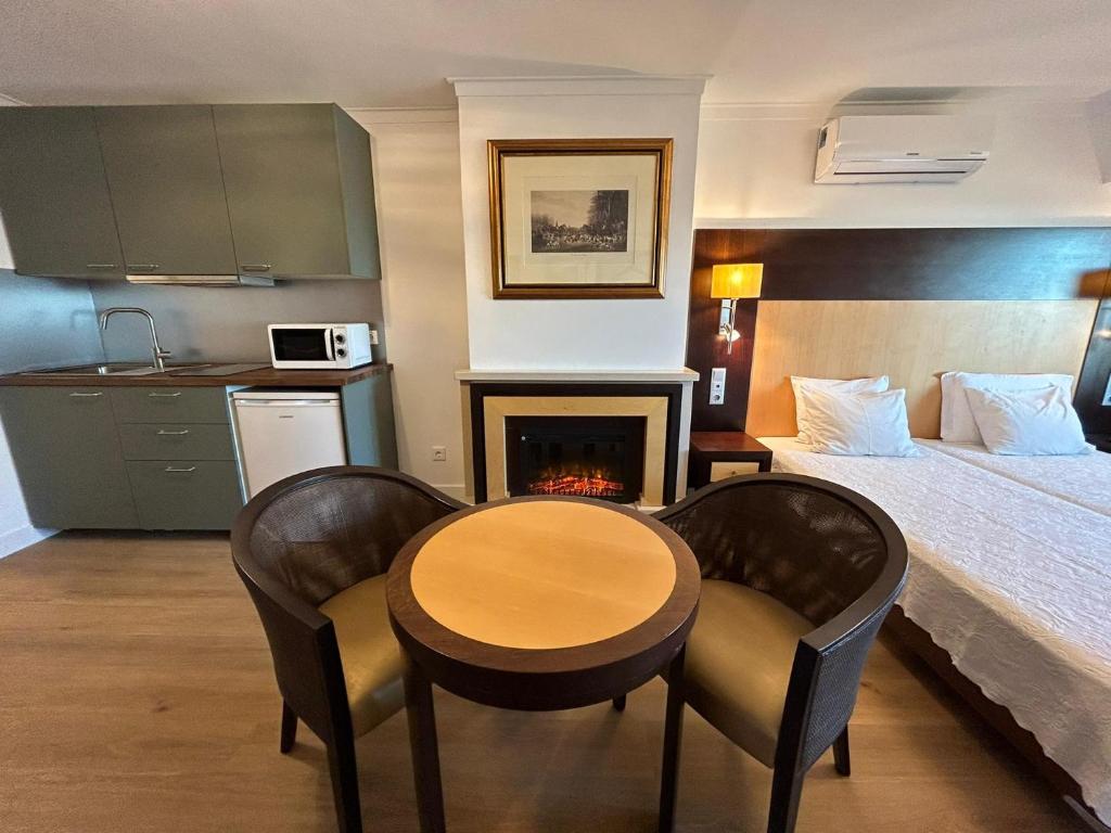 um quarto de hotel com uma cama, uma mesa e cadeiras em Discovery Apartment Carnaxide em Carnaxide