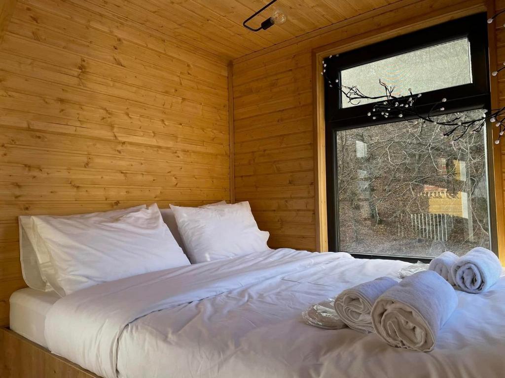 Bett in einem Holzzimmer mit Handtüchern darauf in der Unterkunft Akhatani Inn in Akhatani